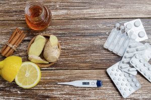 Ginger lemon honey and different drugs with thermometer on wooden background.Alternative remedies and traditional pills to treat colds and flu. Natural medicine vs conventional medicine concept - Forest Medical Calibration Services